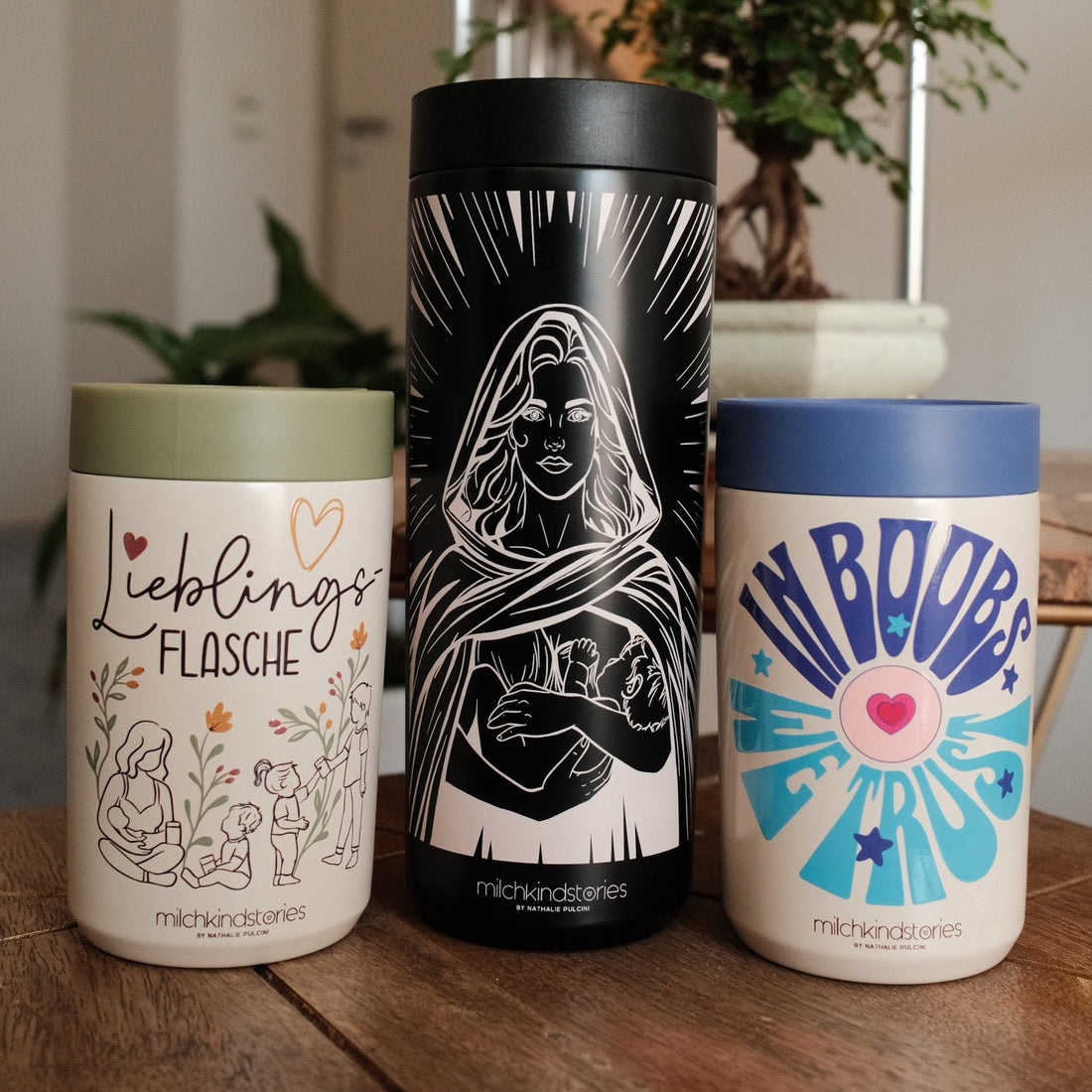 Die drei milchkindstories Trinkflaschen auf dem Holztisch